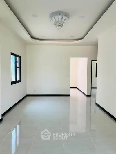 Spacious modern living room with elegant ceiling light and glossy tiled floor