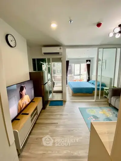 Modern open-plan living room with stylish decor and spacious bedroom view.