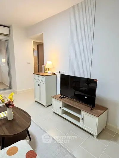 Modern living room with stylish furniture and TV setup, perfect for relaxation.