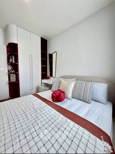 Modern bedroom with stylish decor and built-in storage in a cozy apartment.