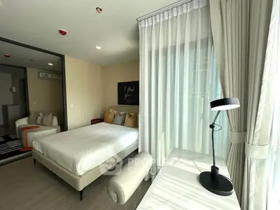 Modern bedroom with natural light, stylish decor, and cozy ambiance in a contemporary apartment.
