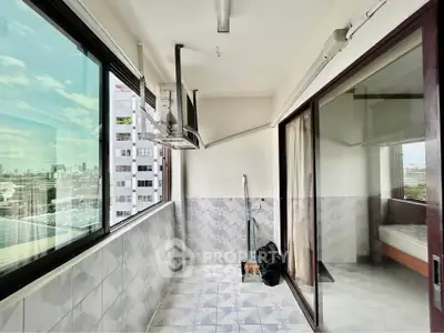 Spacious balcony with city view and sliding glass doors in modern apartment