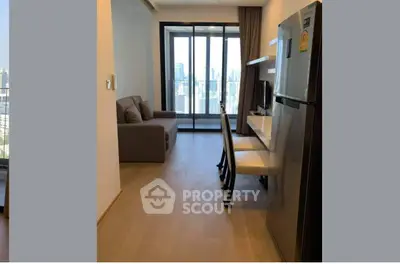 Modern apartment interior with city view, featuring a cozy living area and sleek kitchen appliances.