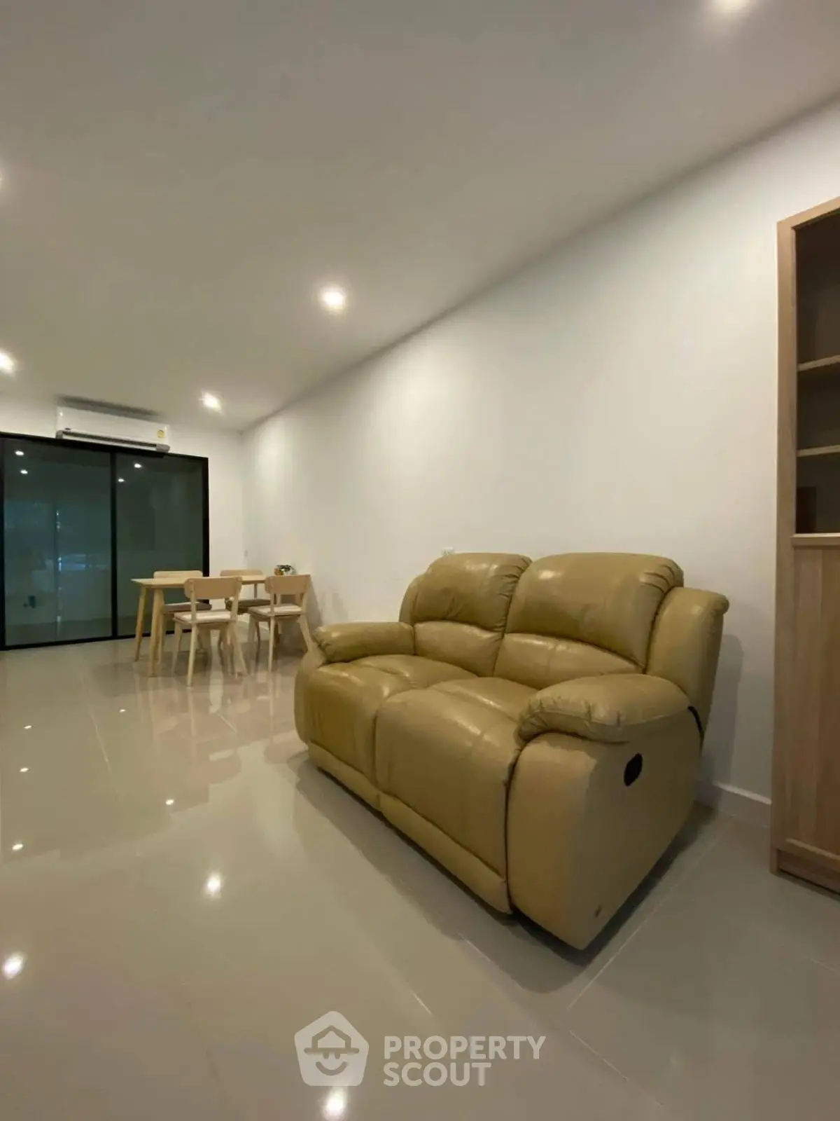 Spacious living room with modern furniture and sleek flooring, perfect for relaxation and entertaining.