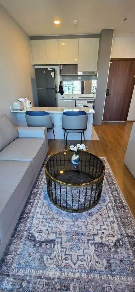 Modern living room with stylish furniture and open kitchen layout in a cozy apartment.