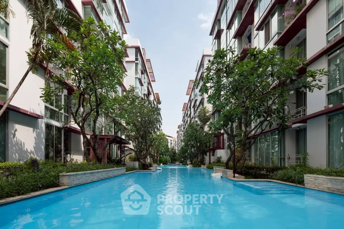 Luxurious residential complex with stunning pool and lush greenery, offering a serene and modern living experience.