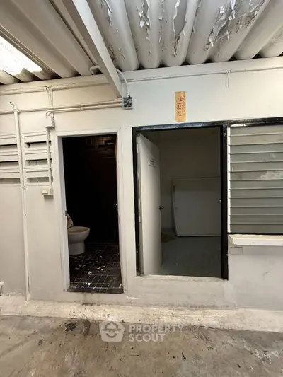 Industrial-style interior with exposed ceiling and open bathroom area.