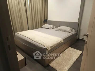 Cozy modern bedroom with stylish decor and plush bedding in a serene setting.