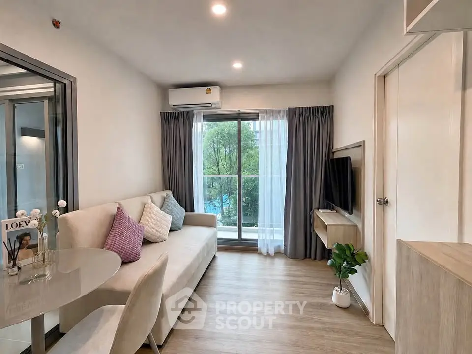 Modern living room with cozy sofa, TV, and balcony view in stylish apartment.