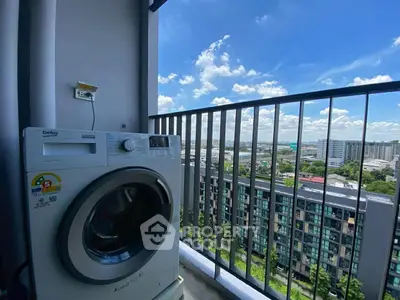 High-rise balcony with washing machine and stunning city view under blue sky.