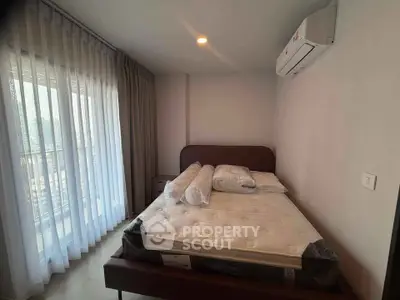 Cozy bedroom with large window and air conditioning in modern apartment