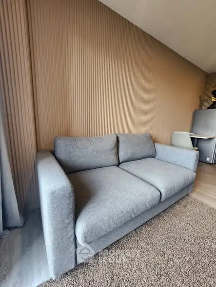 Modern living room with stylish gray sofa and textured wall paneling
