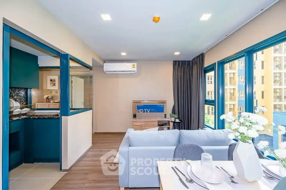Modern living room with open kitchen and large windows in a stylish apartment.