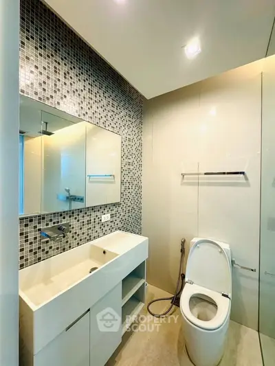 Modern bathroom with sleek fixtures and mosaic tile accent wall