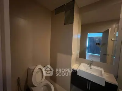 Modern bathroom with sleek fixtures and large mirror in a contemporary home.