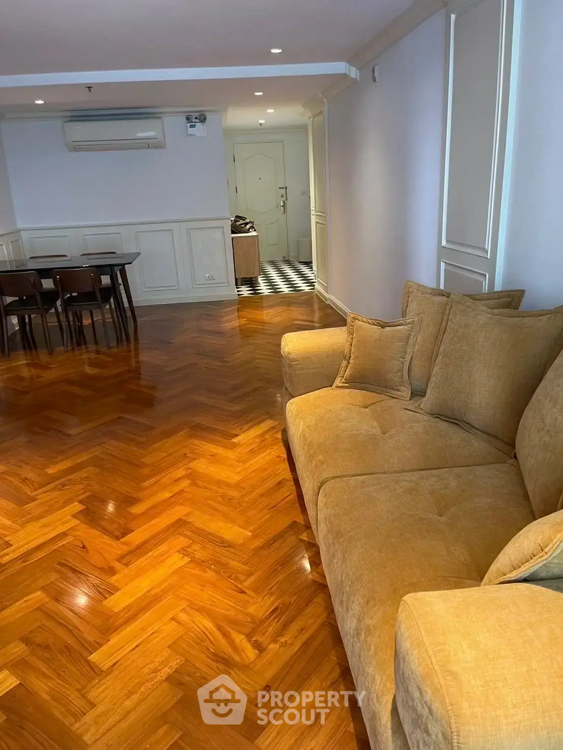 Spacious living room with elegant wooden flooring and cozy seating area.