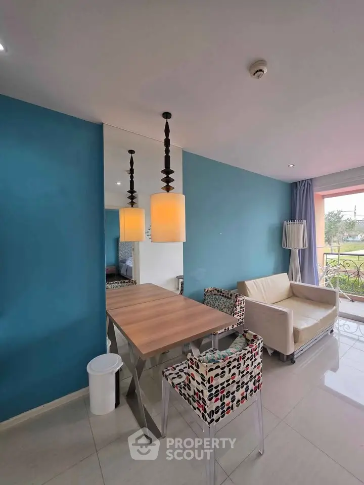 Modern living room with stylish decor, vibrant blue accent wall, and cozy seating area.