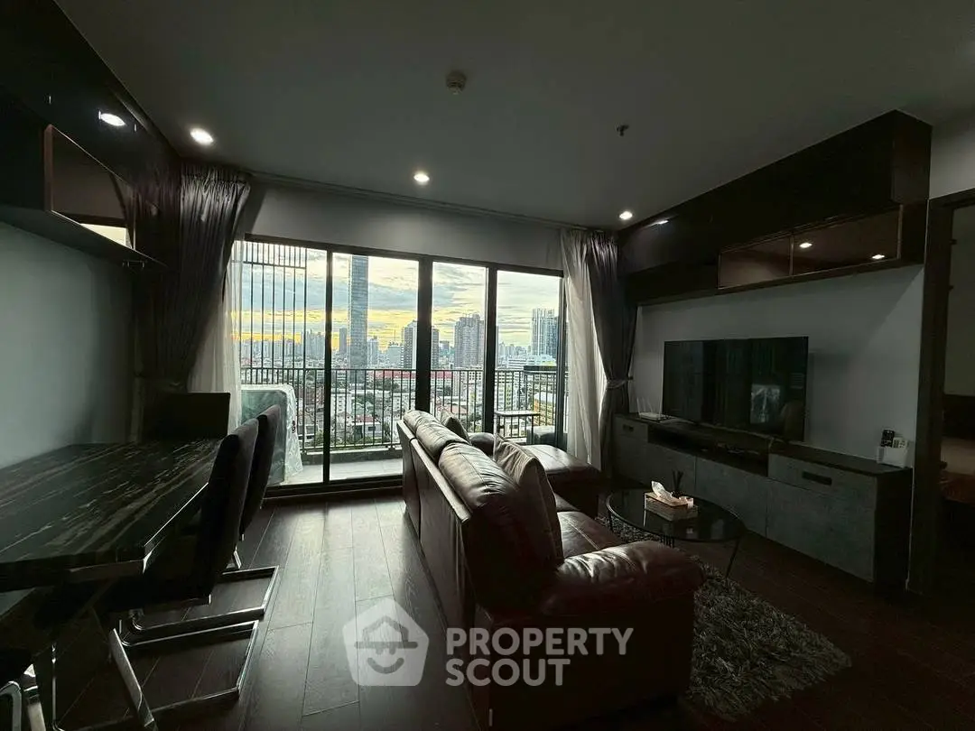 Modern living room with city view, featuring sleek furniture and large windows for natural light.