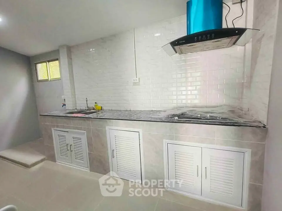 Modern kitchen with sleek countertops and stainless steel range hood