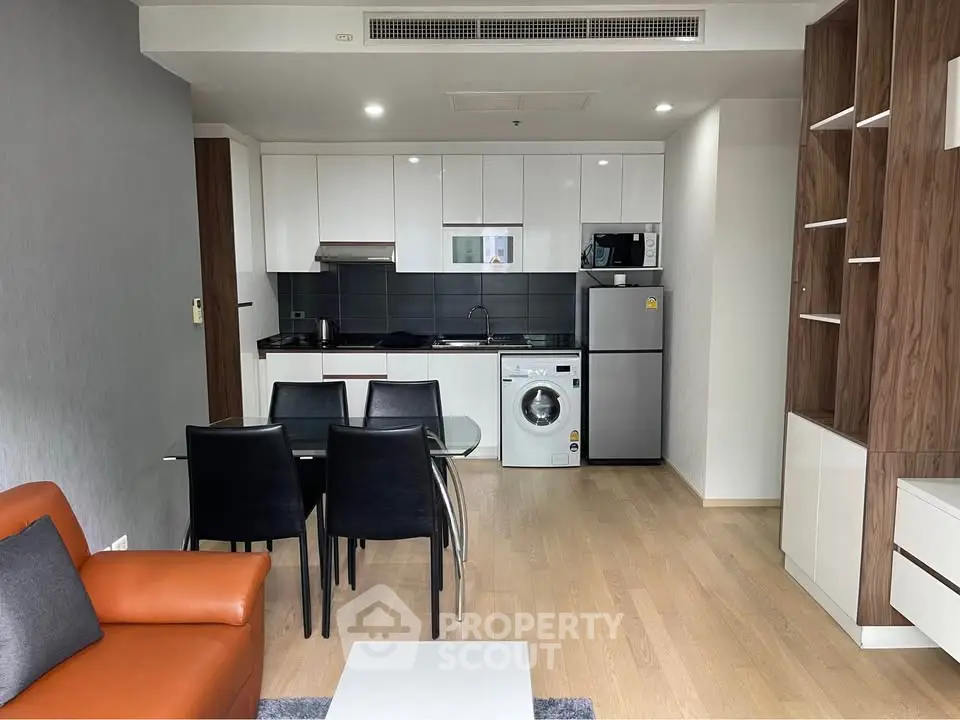 Modern open-plan kitchen and living area with sleek appliances and stylish furniture.