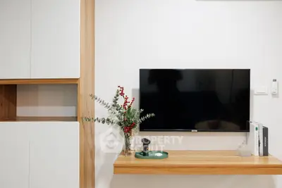 Modern living room with sleek TV setup and stylish wooden shelving.