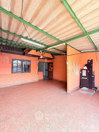 Spacious open area with tiled flooring and orange walls, ideal for creative renovation.