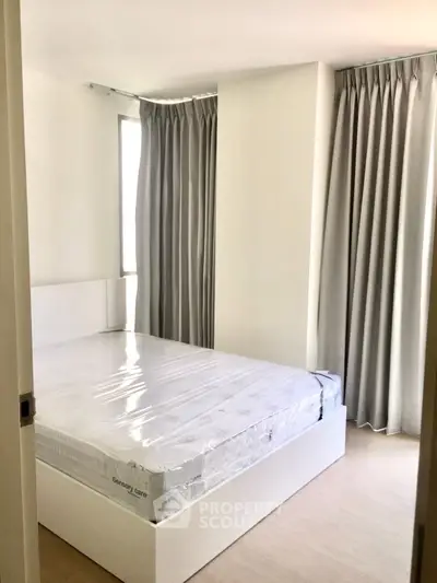 Modern bedroom with natural light and elegant curtains, featuring a new bed setup for comfort and style.