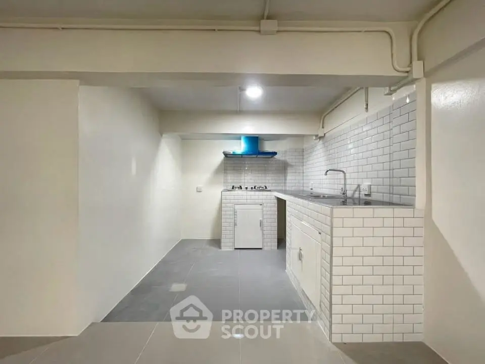 Modern minimalist kitchen with sleek white tiles and compact layout