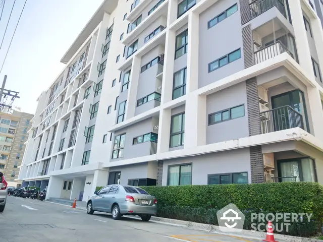 Modern apartment building exterior with clean lines and lush greenery