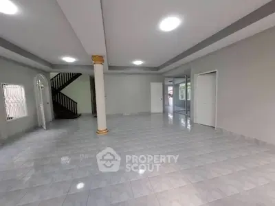 Spacious open-plan living area with elegant column and tiled flooring