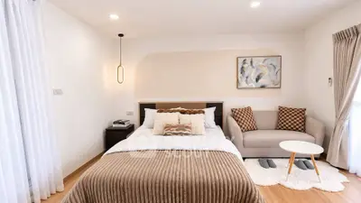Elegant bedroom with cozy decor and modern lighting in a stylish apartment.