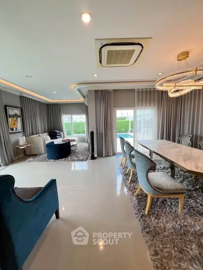 Luxurious living room with elegant decor, plush seating, and modern lighting in a spacious open layout.