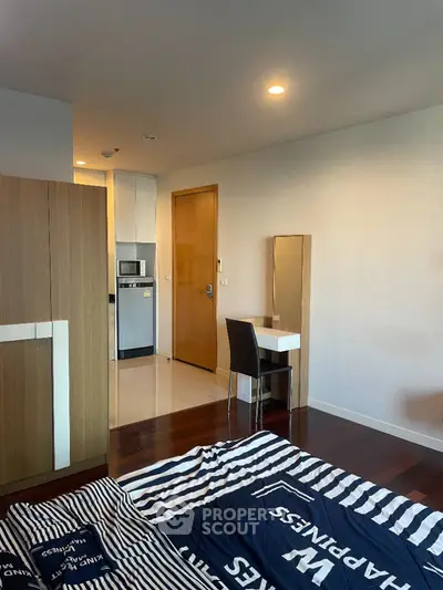 Modern studio apartment with compact kitchen and cozy sleeping area.