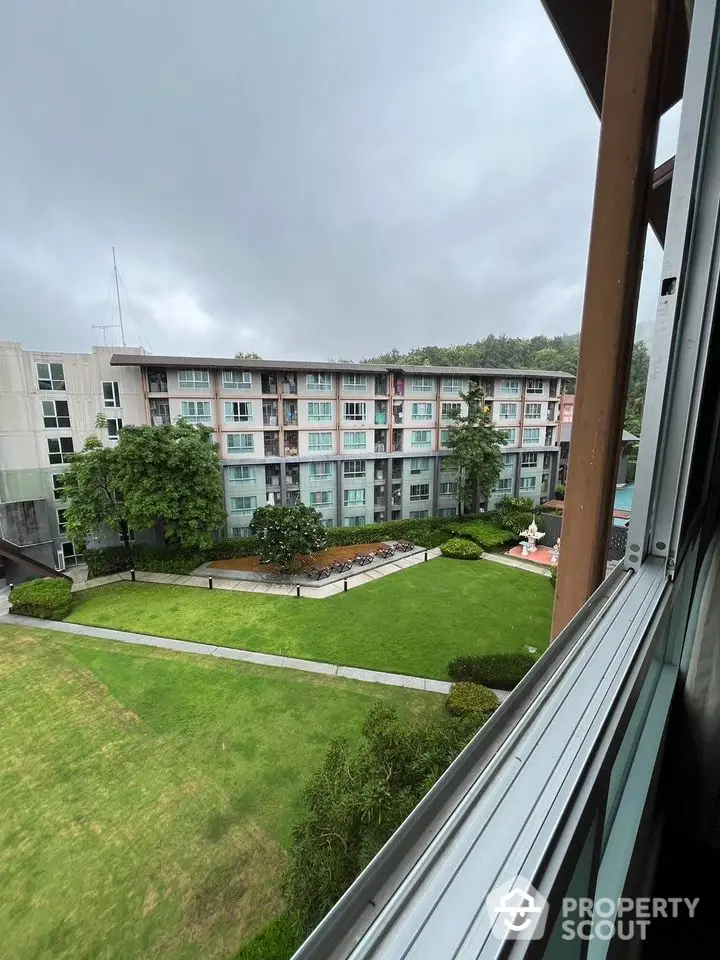 Scenic view of modern apartment complex with lush green garden from window