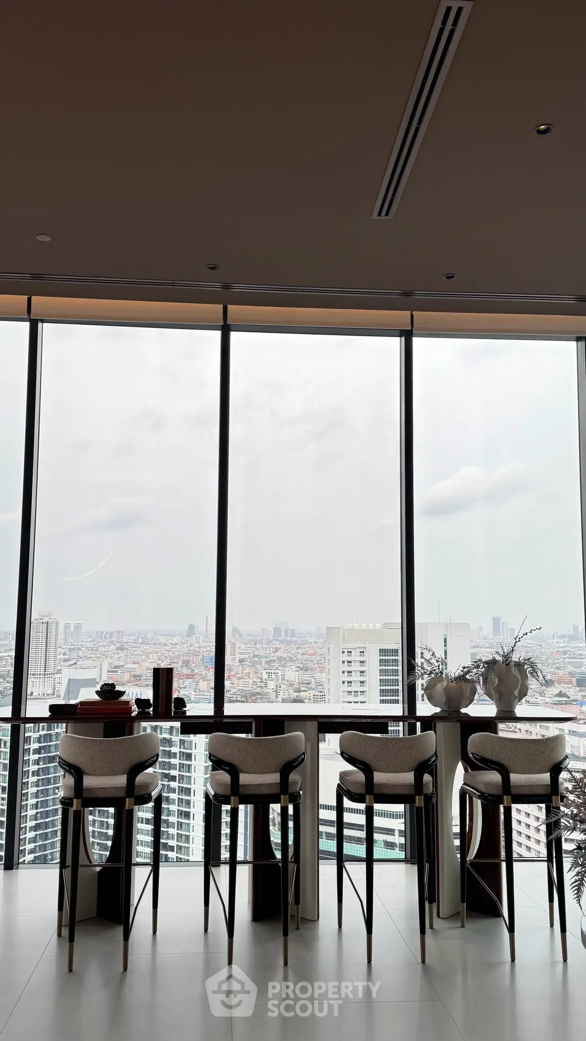 Luxurious high-rise apartment with panoramic city views and elegant bar seating area.