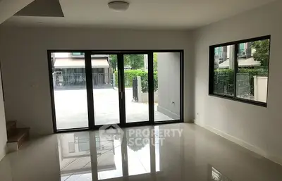 Spacious modern living room with large glass doors and garden view