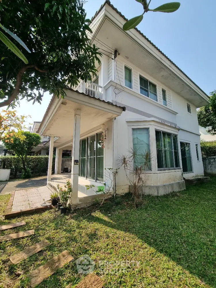 Charming two-story house with lush garden and spacious patio, perfect for family living.