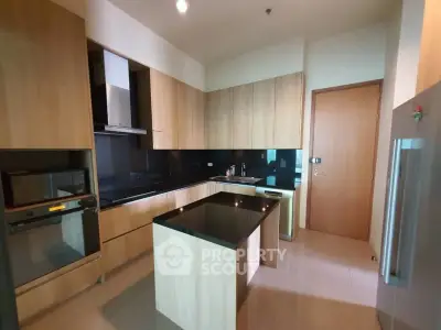 Modern kitchen with sleek wooden cabinetry and black countertops in a luxury apartment.
