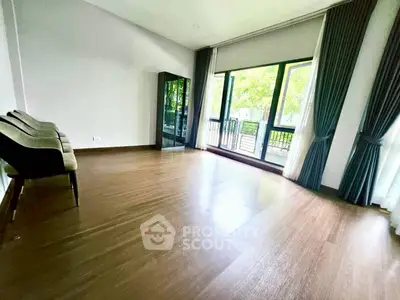 Spacious living room with large windows and wooden flooring
