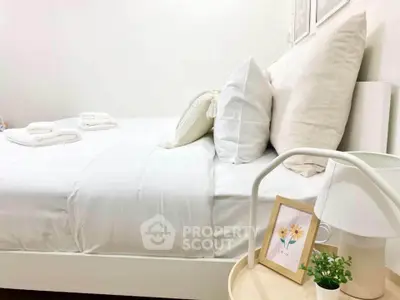 Cozy bedroom with white bedding and decorative pillows, perfect for relaxation.