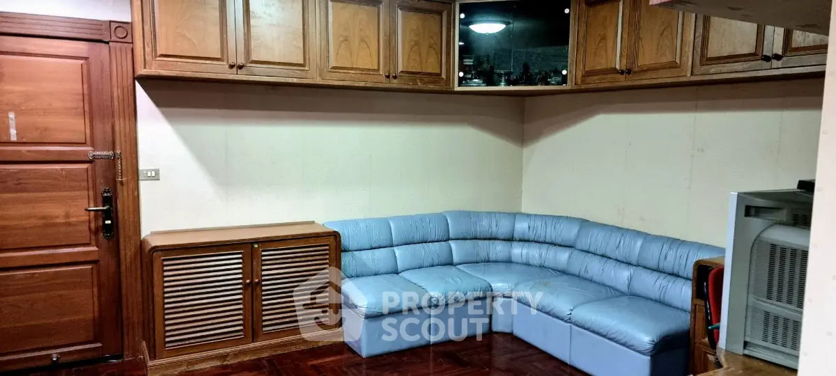 Cozy living room with blue sectional sofa and wooden cabinetry