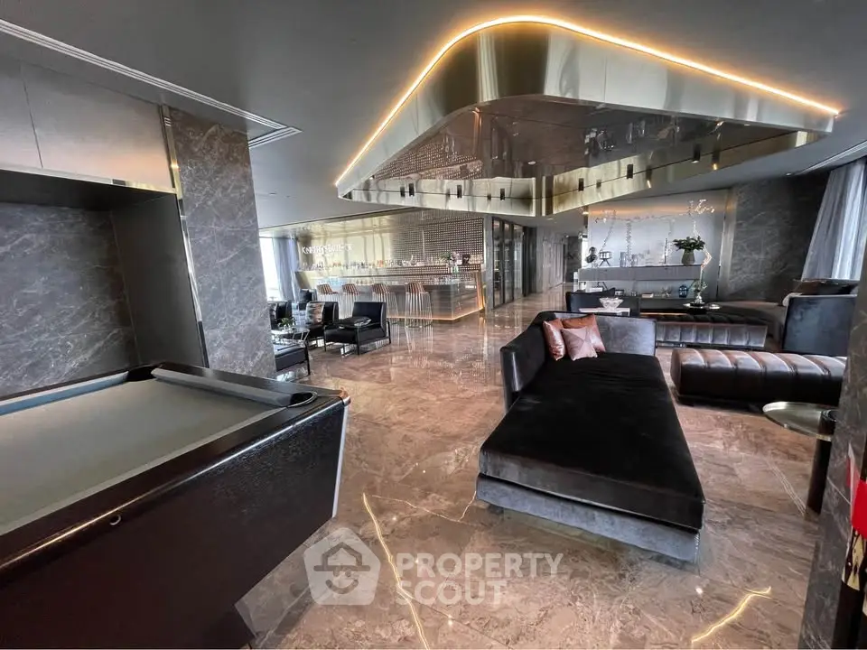 Luxurious modern living room with sleek design and elegant furnishings, featuring a pool table and stylish lighting.