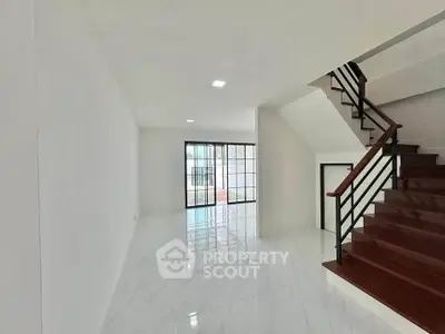 Spacious modern living room with sleek staircase and large windows