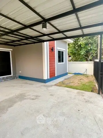 Modern single-story home with covered carport and small garden area.