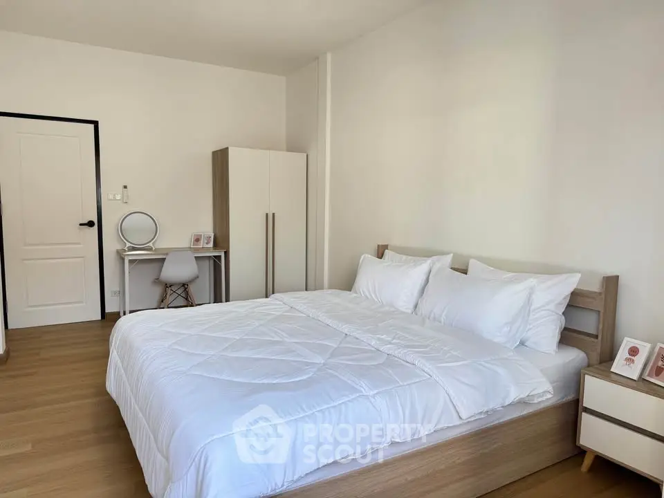 Modern bedroom with cozy bed, minimalist decor, and natural light.