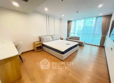 Spacious bedroom with modern furnishings and large windows for natural light