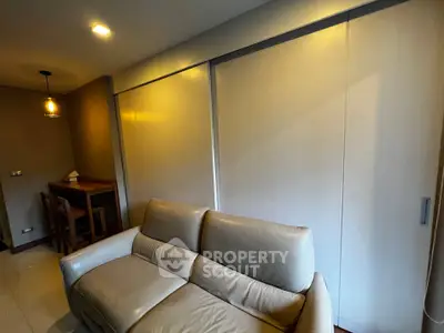 Cozy living room with modern sofa and dining area, perfect for relaxation and entertaining.