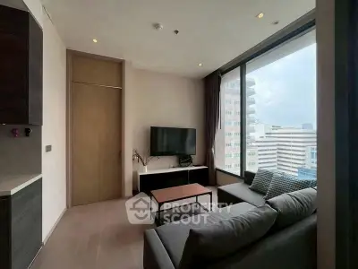 Modern living room with city view, featuring sleek furniture and large windows.