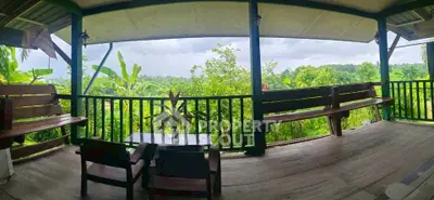 Charming wooden balcony with lush green views, perfect for relaxation and enjoying nature.