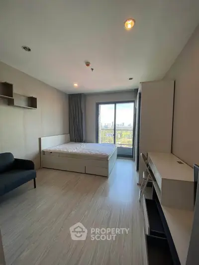 Modern bedroom with city view, featuring sleek furniture and natural light.